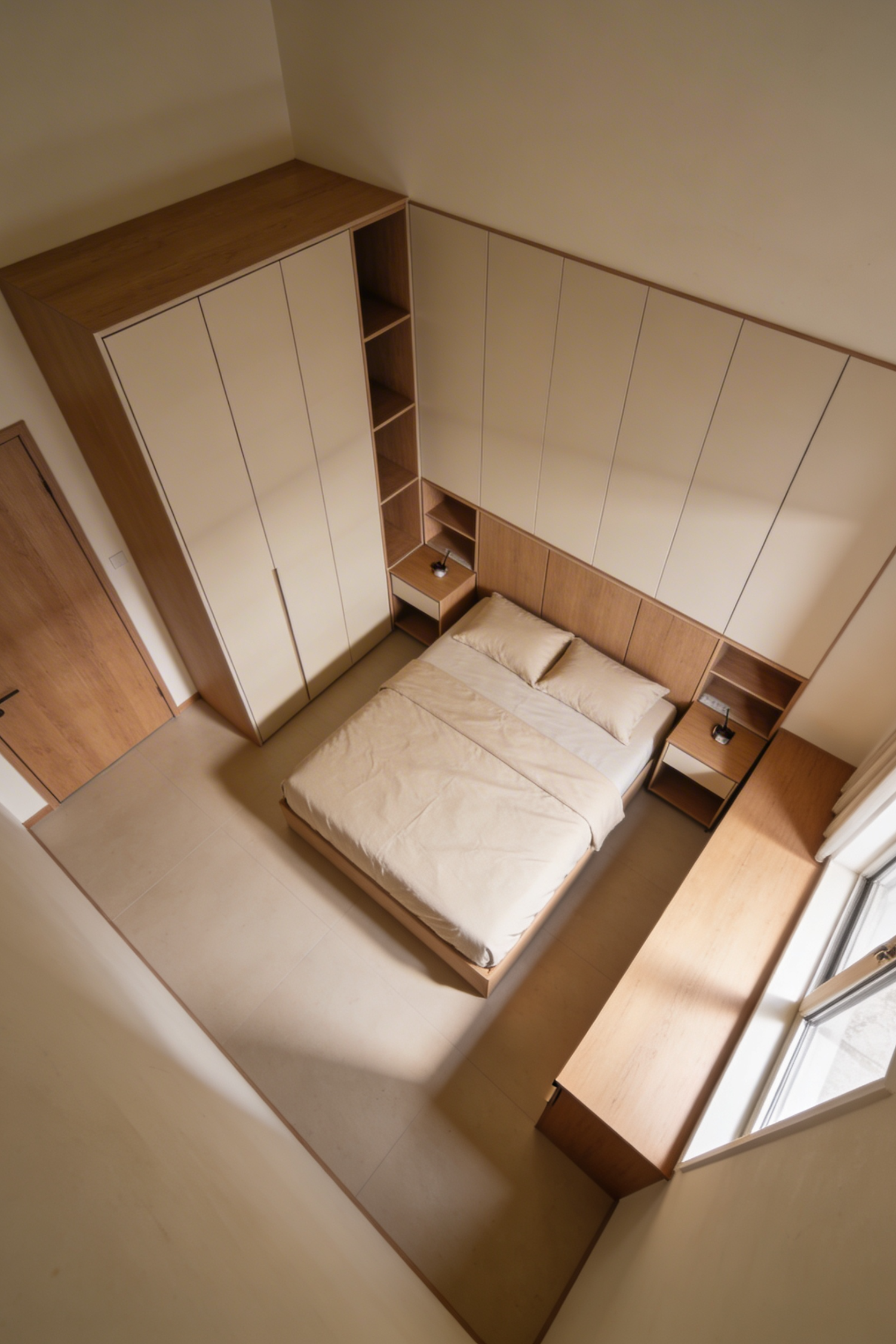Overhead view of a small bedroom with wraparound built-in oak storage framing the bed on three sides